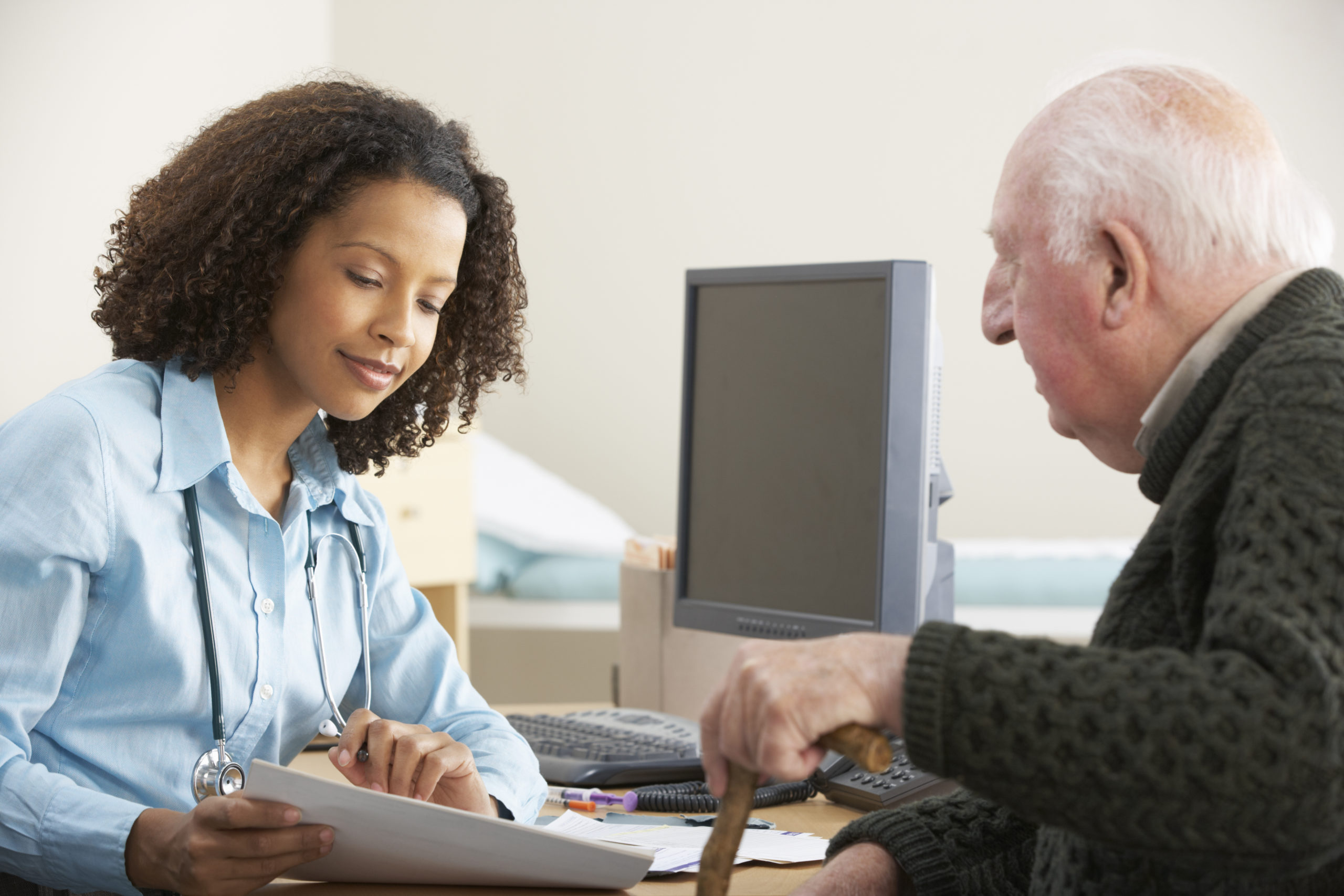 Image of female doctor speaking with an older male patient.